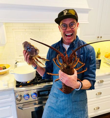 Brian Malarkey in his kitchen poses with crabs.